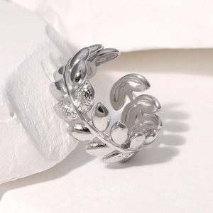Macro shot of silver leaf-shaped adjustable ring displayed on a white textured stone