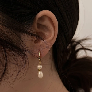 Elegant gold-plated hoop earrings with double baroque freshwater pearls worn by model