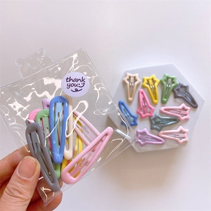 Detail of assorted candy-colored snap hair clips in star and teardrop shapes