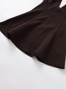 Vue détaillée de l'ourlet de la robe marron foncé montrant la texture du tissu tissé