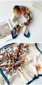 Detailed texture of 70cm silk scarf with orange floral and cat prints on cream fabric