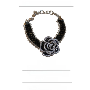 Gros plan du bracelet fleur en cristal noir montrant les strass et le fermoir mousqueton