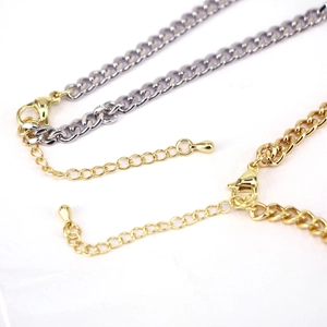 Detailed macro view of gold and silver necklaces with lobster clasps and extension chains