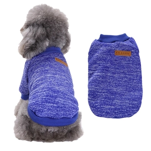Detail of blue knitted dog sweater with classic leather tag and warm knit texture