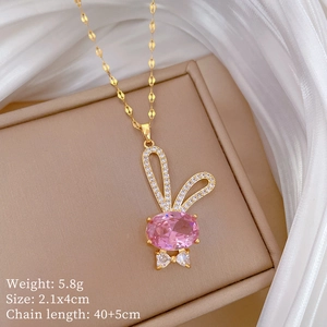 Détail du pendentif lapin avec gemme rose et cristaux brillants sur chaîne dorée