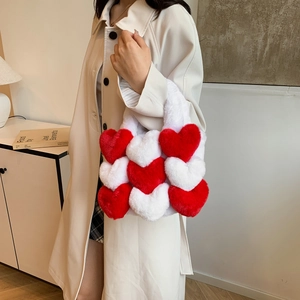 Detail of plush heart-shaped tote bag in red and white with soft fuzzy texture