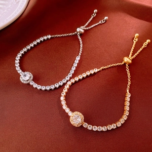 Détail de bracelets bolo ajustables en or et argent sur un tissu en velours rouge