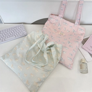 Detailed close-up of cute cartoon cat print canvas tote bags in pink and light cyan colors