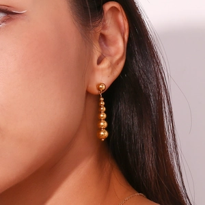 Close-up of elegant 18K gold plated peanut-shaped gradient bead drop earrings on a model