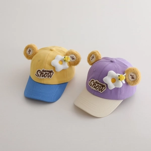 Détail de casquettes enfant avec écussons fleurs abeilles 3D et oreilles en peluche