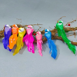 Detailed view of colorful artificial feathered birds perched on a rustic natural branch