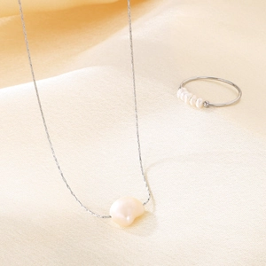 Elegant irregular freshwater pearl pendant necklace and slim pearl ring on silk fabric