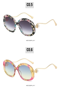 Detail view of round vintage sunglasses with pearl decor and stylish metal temples