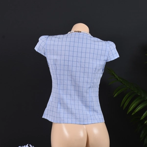 Detail view of the blue and white checkered short sleeve blouse on a female mannequin