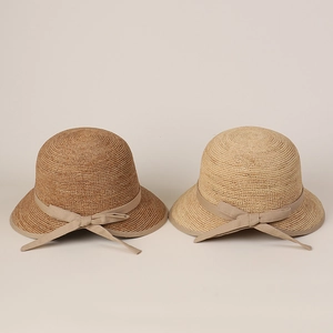 Detail of high-end raffia straw hats in brown and beige with elegant bow ribbons