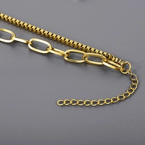 Detailed macro view of a layered golden stainless steel chain with adjustable clasp