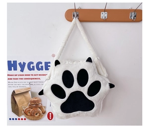Detail of plush cat paw shoulder bag with black padding on a cozy white background