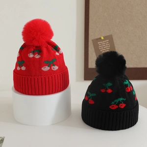 Winter kids knit hat with cherry jacquard and faux fur pom-pom in red and black