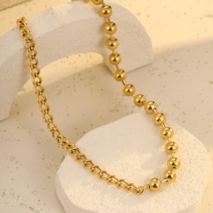 Detail of gold-plated stainless steel necklace with mixed ball and link chain design
