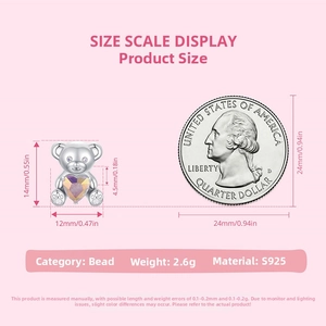 Detalle del charm de oso en plata S925 con corazón junto a una moneda estadounidense