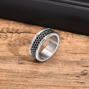 Macro shot of stainless steel ring with black cubic zirconia stones and textured edges