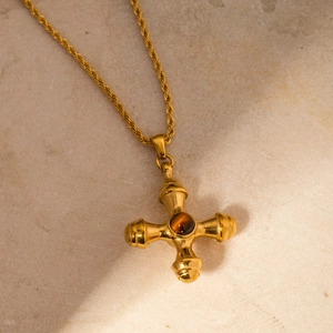Close-up of 18k gold plated cross necklace featuring a brown tiger eye stone on marble