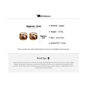 Detail of round leopard pattern stud earrings with silver needles and copper material