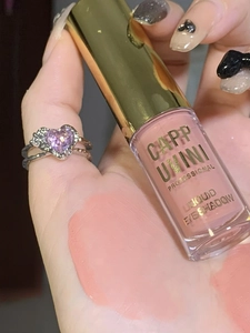 Detailed swatches of matte nude pink liquid eyeshadow on hand with clear bottle packaging