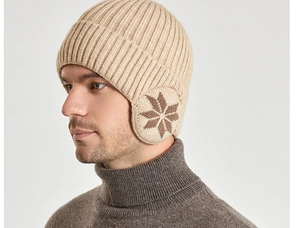 Detail van de beige gebreide muts met oorkleppen en bruin sneeuwvlokpatroon voor heren