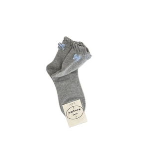 Light grey cotton socks with blue bow and ruffled cuffs in minimalist retail packaging