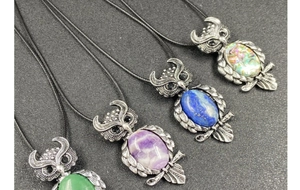 Detailed view of owl pendants with natural gemstone inlays and vintage silver finish