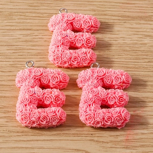Detailed view of pink rose-textured letter E charms for DIY jewelry making crafts