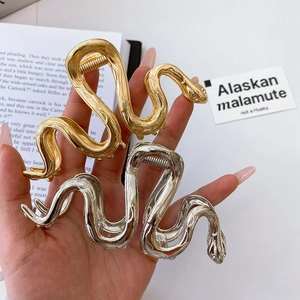 Detail of snake-shaped gold and silver metal hair claws with lifelike scale textures