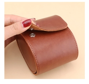 Detail view of premium brown leather watch case with silver metal snap and fine stitching