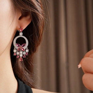 Close-up of silver earrings with pink and white cubic zirconia in flower and fringe tassel style