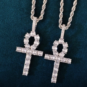 Macro shot of silver Ankh cross pendants with sparkling cubic zirconia on blue velvet
