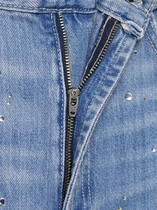 Détail macro du pantalon en jean avec fermeture éclair en métal et strass brillants