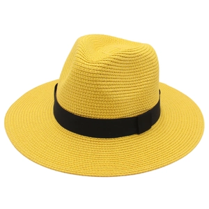 Detail of yellow Panama hat showing woven straw texture and a black ribbon band decor