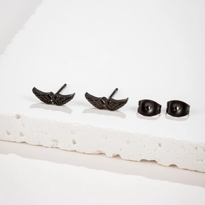 Mattschwarze Edelstahl-Engelsflügel-Ohrstecker auf einem weißen Steinsockel präsentiert