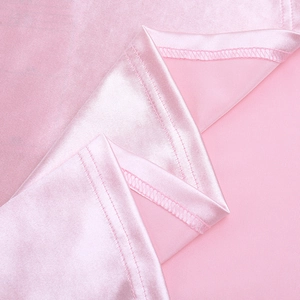 Dettaglio della cucitura in raso rosa con trame di tessuto pregiato sull'abito aderente