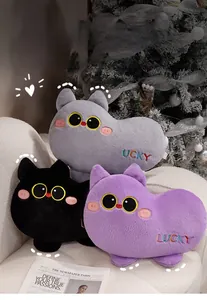 Plush cat pillows with rainbow Lucky embroidery on a sofa by a Christmas tree