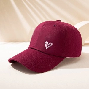 Classic burgundy cotton baseball cap featuring white heart embroidery on a minimalist stand