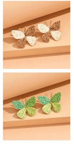Detail of woven raffia butterfly earrings in brown, beige, and green color options