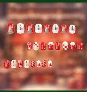 Close-up of Christmas press-on nails with Santa Claus and glitter tree patterns