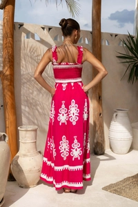 Detail of bohemian floral maxi dress featuring smocked elastic back and vibrant pink print