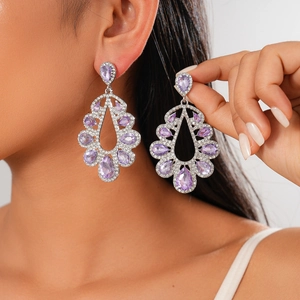 Detailed close-up of water drop earrings with purple stones and crystals on model