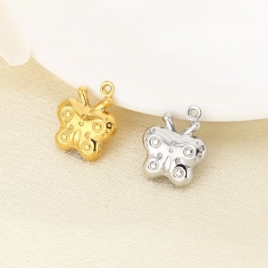 Detailed view of hollow butterfly charms in polished gold and silver stainless steel