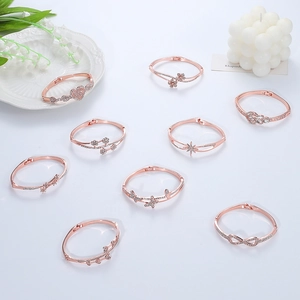 Detailed view of nine rose gold plated bracelets with crystal charms on a decorative tray