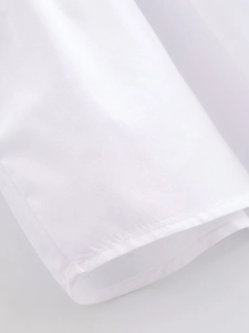 Gros plan détaillé montrant la texture fine du coton et les coutures propres du haut blanc