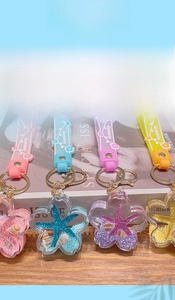 Close-up of star-shaped liquid sea animal keychains in pink, blue, purple, and yellow